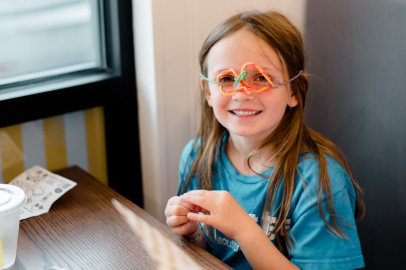 young girl at Over Easy Sioux Falls with makeshift eyeglasses made